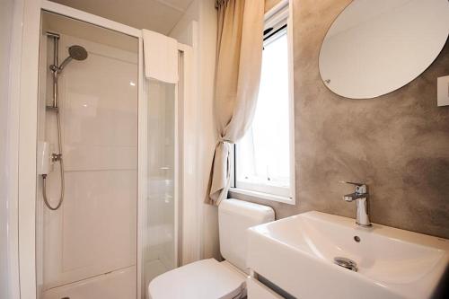a bathroom with a toilet and a sink and a mirror at Camping Europa in Capoliveri