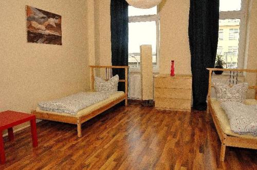 Pokój z 2 łóżkami i drewnianą podłogą w obiekcie 3-Raum-Fewo-Dresden-Zentrum-Balkon-Blick-auf-Altstadt-L10 w Dreźnie