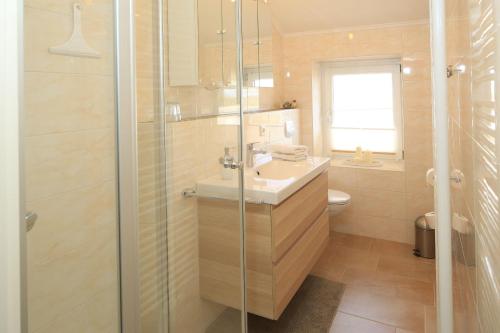 W łazience znajduje się umywalka i prysznic. w obiekcie Ferienwohnung-Oben w mieście Elisabeth-Sophien-Koog