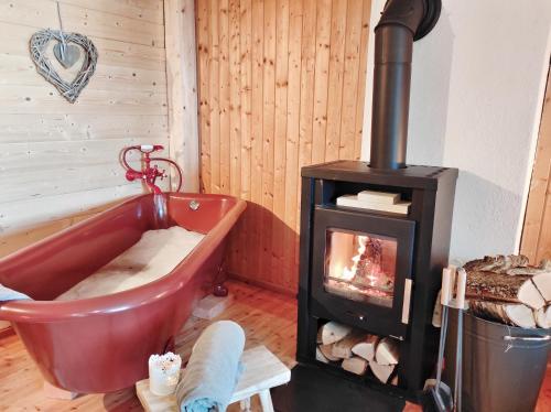 a room with a bath tub and a stove at Hütte Gerlitzen RegioJet Hotels&Cottages in Bodensdorf
