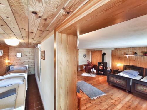 ボーデンスドルフにあるHütte Gerlitzen RegioJet Hotels&Cottagesの木製の天井の客室とベッド付きの客室を提供しています。