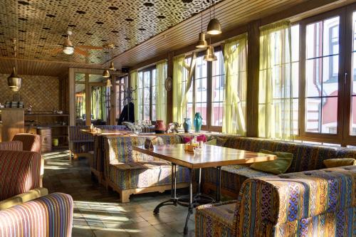 um restaurante com sofás, uma mesa e janelas em Parade Hotel Yaroslavl em Yaroslavl