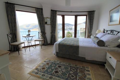 a bedroom with a bed and a balcony with a view at Villa Amare in Kalkan
