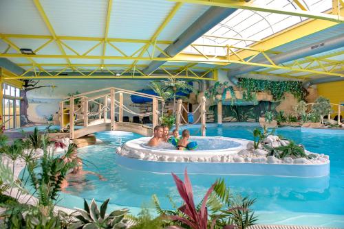 una familia en una piscina en un parque acuático en Camping Bel Air, en Les Sables-dʼOlonne