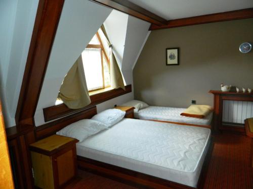 two beds in a room with a window at Idila in Kruševac