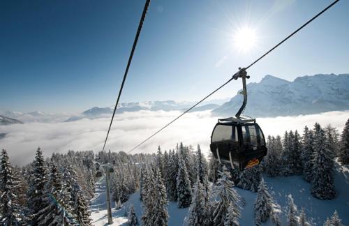 a ski lift flying over a snow covered mountain at Oskar Apartments in Neustift im Stubaital
