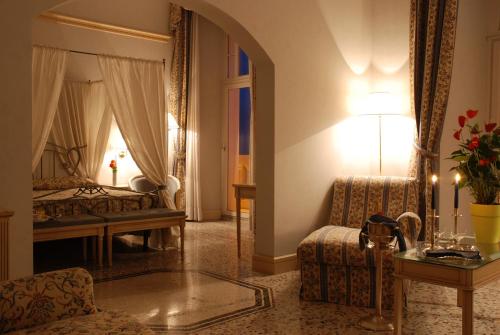 a living room with a couch and a bed at Hotel De La Ville in Civitavecchia