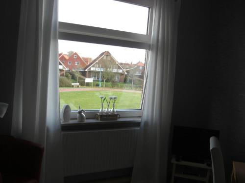 ein Fenster mit Blick auf einen Hof in der Unterkunft Ferienzimmer Becker in Werdum