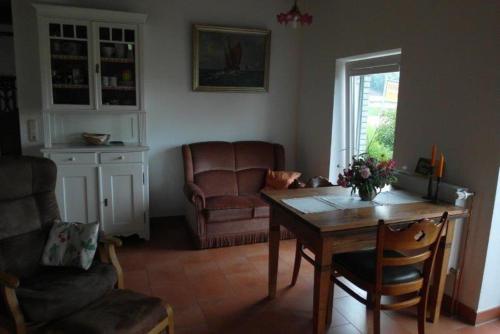 ein Wohnzimmer mit einem Tisch und einem Stuhl in der Unterkunft Ferienhaus Krohn Schleiblick in Ulsnis