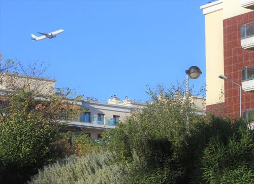 a building with a plane flying in the sky at Cosy Rooms in Sacavém