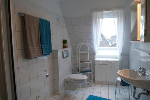 クックスハーフェンにあるHaus-Mueckenbergerのバスルーム(トイレ、洗面台付)、窓が備わります。