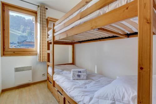 a bedroom with two bunk beds and a window at Slalom Apartment - Very Town Centre - Snow and Trek - Morzine in Morzine