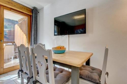 a dining room with a wooden table and chairs at Slalom Apartment - Very Town Centre - Snow and Trek - Morzine in Morzine