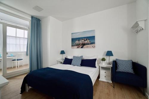 オストゼーバート・ゼリンにあるFerienappartement-Granitz-03のベッドルーム1室(ベッド1台、椅子付)