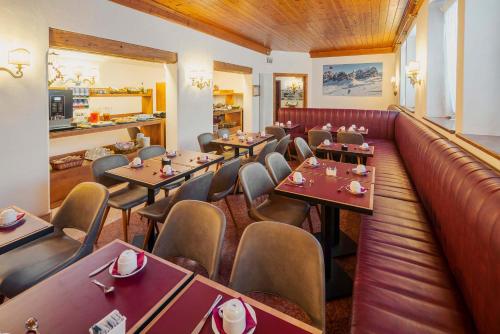 un ristorante con tavoli e sedie e un bar di Royal Hotel Cortina a Cortina dʼAmpezzo