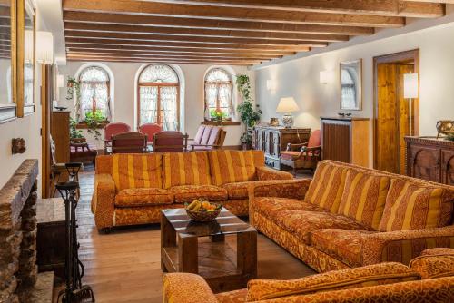 - un salon avec des canapés orange et une table dans l'établissement Royal Hotel Cortina, à Cortina dʼAmpezzo