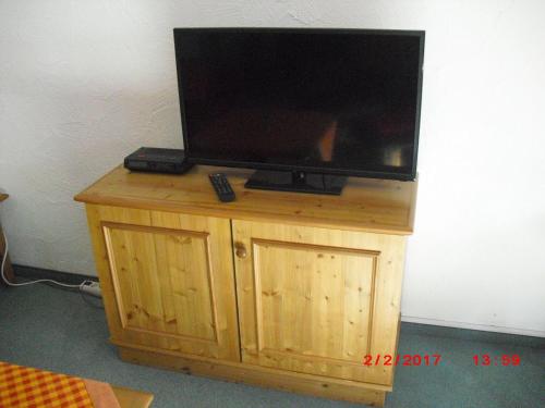 a flat screen tv sitting on top of a wooden stand at Allgaeublick-App23-Gaestehaus-in-Bad-Hindelang in Bad Hindelang