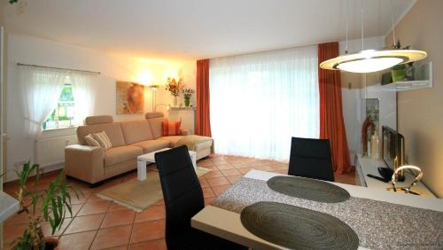 een woonkamer met een bank en een tafel en stoelen bij Gaestehaeuser-Heidehof-Wohnung-5 in Süderhöft