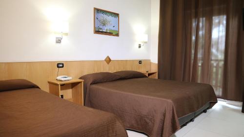 ein Hotelzimmer mit 2 Betten und einem Telefon in der Unterkunft Hotel Meranda in Camigliatello Silano