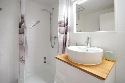 een witte badkamer met een wastafel en een douche bij Alpseenest in Immenstadt im Allgäu