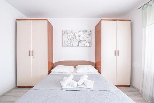 a bedroom with a bed with white cabinets at Apartments Vukic in Crikvenica