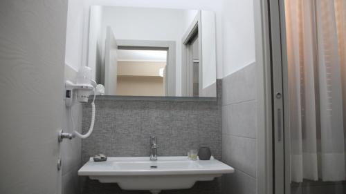 un baño con lavabo y espejo en Le Anfore Appartamenti, en Lampedusa