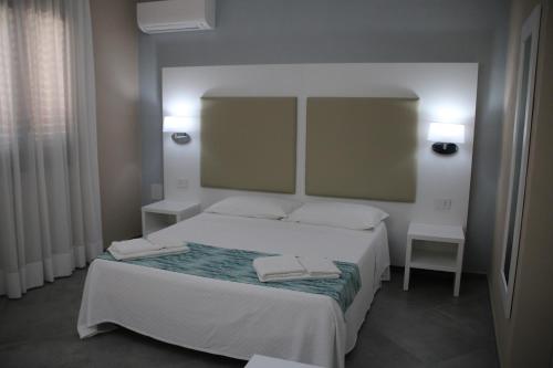 ランペドゥーザにあるLe Anfore Appartamentiのベッドルーム1室(ベッド1台、タオル2枚付)