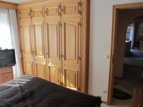 オーベルストドルフにあるAalener-Haus-Wohnung-3のベッドルーム(ベッド1台付)内の大きな木製キャビネット