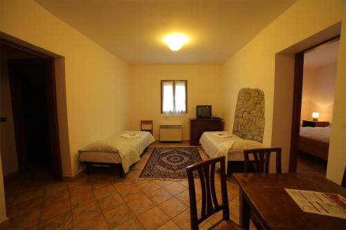 a room with two beds and a table and chairs at Villaggio Della Salute Più in Monterenzio