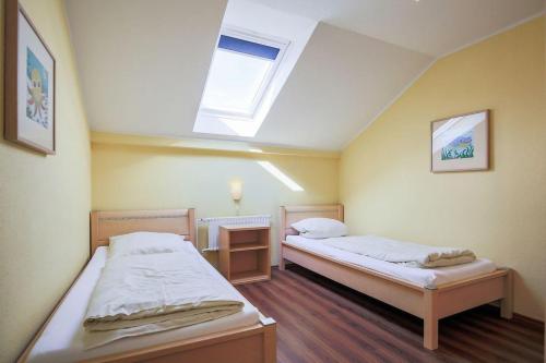 two beds in a room with a skylight at Buedlfarm-Sued in Sahrensdorf