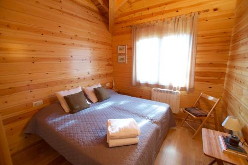 a bedroom with a bed in a wooden cabin at Cabana Coll Sisé in La Molina
