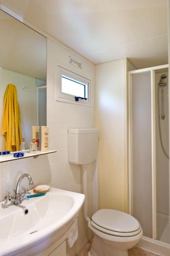 a white bathroom with a toilet and a sink at Camping Village Rosselba Le Palme in Portoferraio