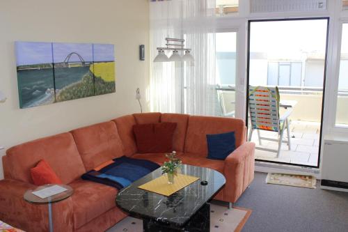 ein Wohnzimmer mit einem Sofa und einem Glastisch in der Unterkunft Direkt am Südstrand in Burgtiefe auf Fehmarn 
