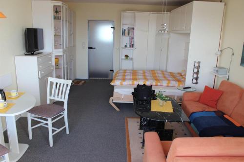 ein Wohnzimmer mit einem Sofa und einem Bett in der Unterkunft Direkt am Südstrand in Burgtiefe auf Fehmarn 