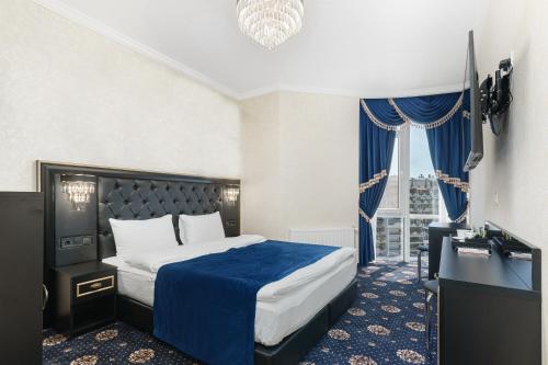 a hotel room with a bed and a desk and a window at Apart Hotel D'Monica in Odesa