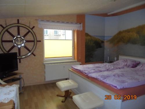 1 dormitorio con 1 cama y 1 rueda en la pared en Apartment Kajüte, en Warnemünde