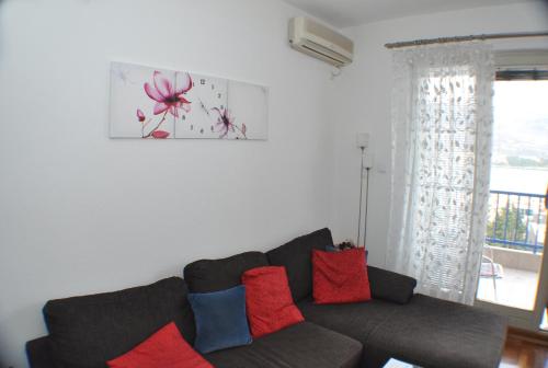 a living room with a couch with red and blue pillows at Belvedere Apartments in Budva
