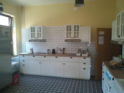 uma cozinha com armários brancos e uma parede de azulejos em House Budkovič em Bohinj