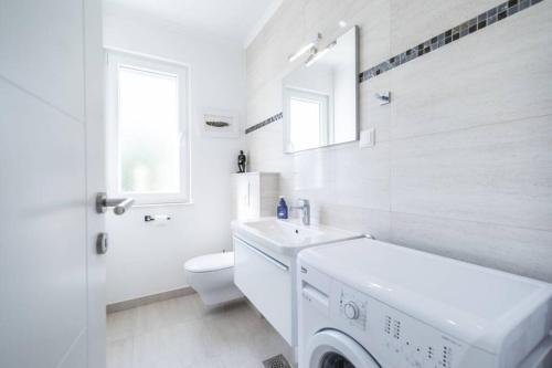 W białej łazience znajduje się pralka. w obiekcie Luxury Apartment Marina View No 3 w mieście Vela Luka