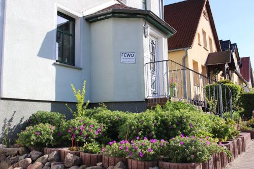 a house with a flower garden in front of it at Ferienwohnung-Amsel-kinderfreundliche-Unterkunft-in-zentraler-Lage in Bergen auf Rügen