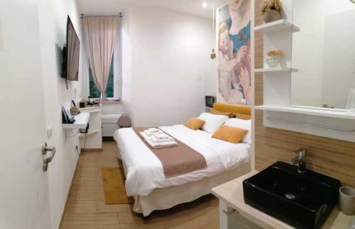 Schlafzimmer mit einem Bett, einem Schreibtisch und einem Waschbecken in der Unterkunft Abbracci leandra Rooms in Civitavecchia