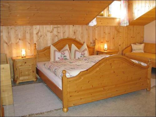 ein Schlafzimmer mit einem großen Holzbett mit zwei Nachttischen in der Unterkunft Haus Spannbauer - Wohnung Fuchsenstein in Altreichenau
