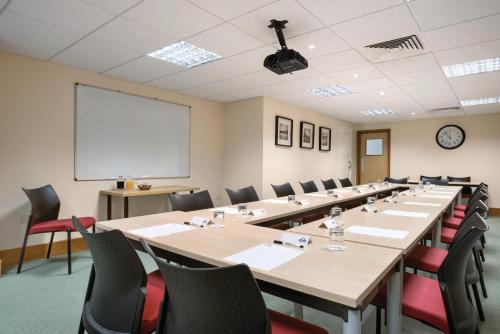a conference room with tables and chairs and a whiteboard at Days Inn by Wyndham Donington in Castle Donington