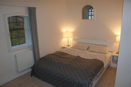 ein Schlafzimmer mit einem Bett, zwei Lampen und einem Fenster in der Unterkunft Heverkoog in Osterhever