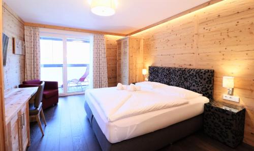 a bedroom with a large white bed in a room at Alpin & See Resort - Pinzgau Holidays in Zell am See