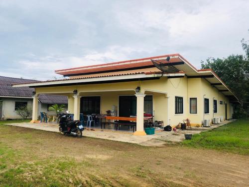 a house with a motorcycle parked in front of it at เกาะลิบงซันไรส์ โฮมสเตย์ Koh libong sunrise Homestay in Ko Libong