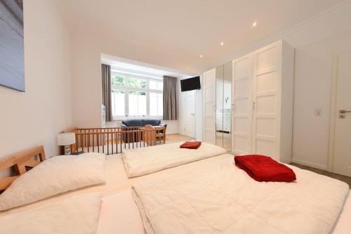 ビンツにあるVilla Eden Binz Typ 6 / Apartment 1のベビーベッド付きのベッドルームに大型ベッド2台が備わります。