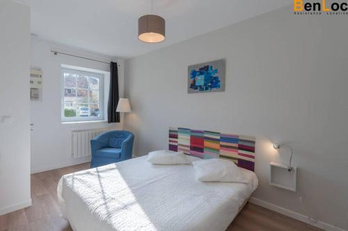 - une chambre avec un lit et une chaise bleue dans l'établissement appart 39m2 avec Terrasse et jardin parking Netflix wifi Pas besoin de passe sanitaire, à Biéville-Beuville