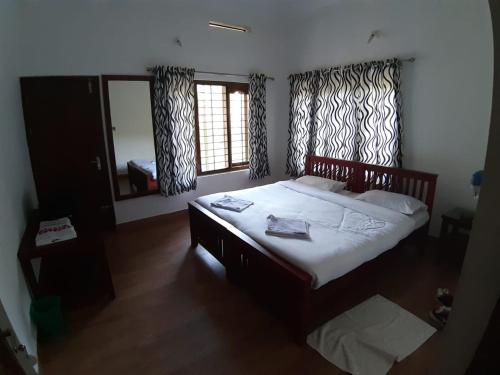 a bedroom with a large bed and a window at Spice Fields Cottage - 3 Bedroom - Wayanad in Wayanad