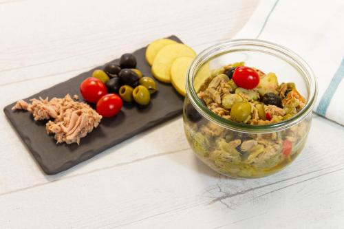 a salad in a jar next to a cutting board with food at Comfort Aparthotel Nantes La Beaujoire in Nantes